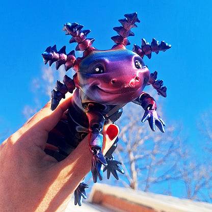 Hand holding a vibrant articulated axolotl model, 3D printed in 'Universe' color Eryone Silk Rainbow PLA, with a clear blue sky background.