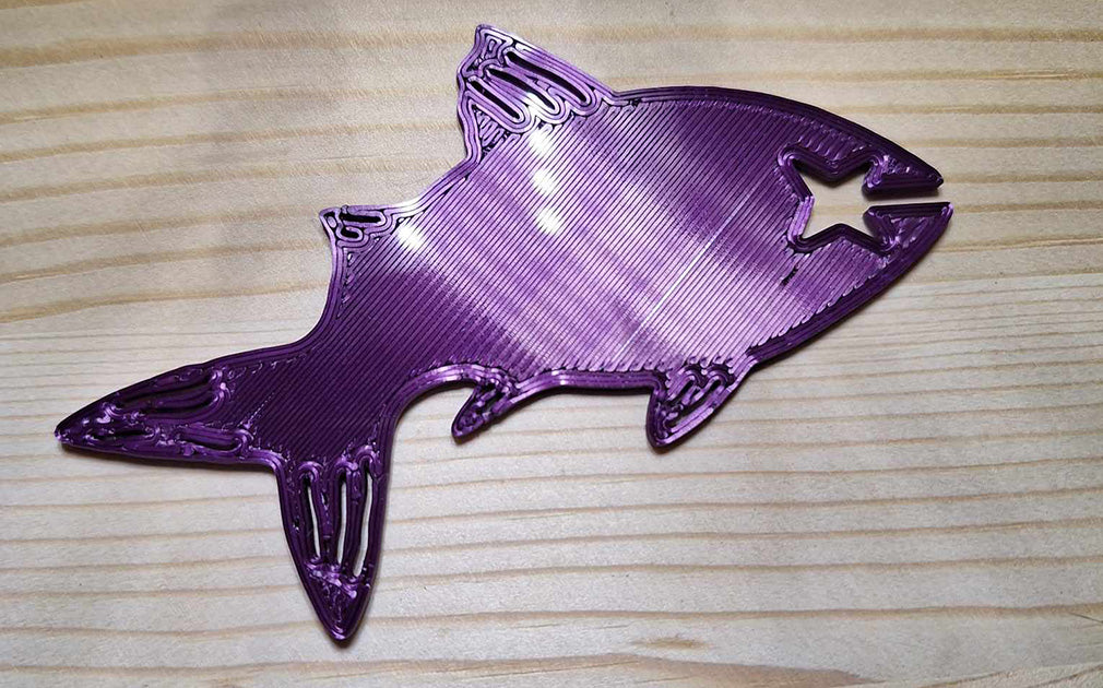 Creality purple silk PLA Fishy Bite Bread & Bag clip lying on a wooden surface, its silk finish gleaming with a lustrous sheen. The clip, designed to resemble a fish, combines functionality with an elegant, vibrant purple color, adding a touch of whimsy to everyday tasks.