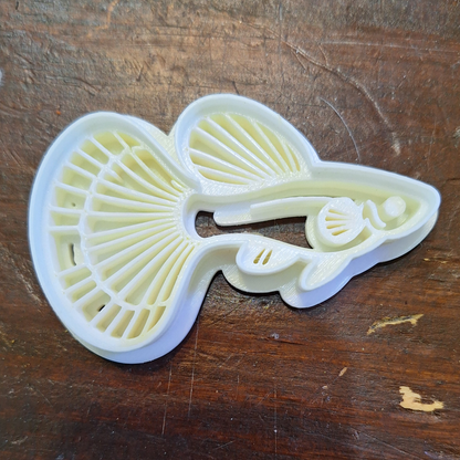 Detailed fancy tail guppy cookie/clay stamp cutter in Creality White PLA, featuring textured surface design for intricate patterns, on a wooden background.