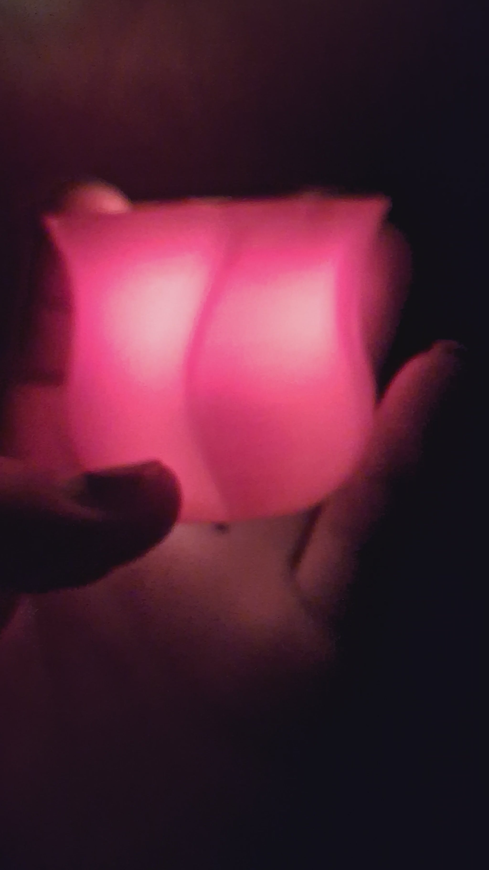 Video of a red 3D-printed rose with a flickering electronic tealight in the dark, highlighting the realistic flame effect, ending as the light is turned off and the scene fades to black.